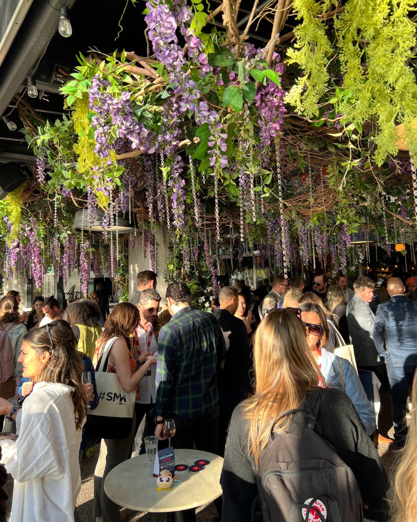 A large group of people mingling outside a restaurant